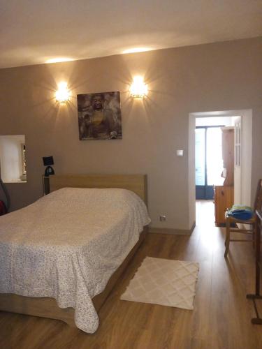 um quarto com uma cama e duas luzes na parede em Appartement au cœur du Village em Saorge