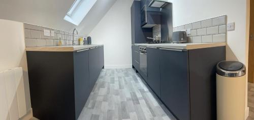 a kitchen with black and white cabinets and a sink at Lochside Loft - Self Catering Apartment for 2 In a great location for Inverness Airport and both Cabot Highlands & Nairn Golf Courses in Inverness