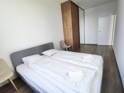 a bedroom with a white bed with two towels on it at Quietly oriented apartment with free parking and balcony in Bratislava