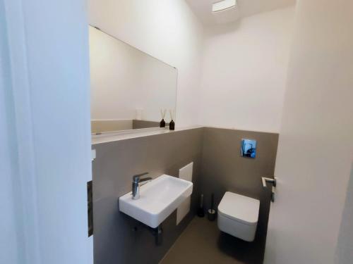 a bathroom with a sink and a toilet at Quietly oriented apartment with free parking and balcony in Bratislava