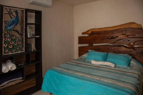 a bedroom with a bed with blue sheets and blue pillows at Aldea Agape in Puerto Morelos
