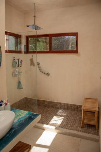 a bathroom with a glass shower with a sink at Aldea Agape in Puerto Morelos