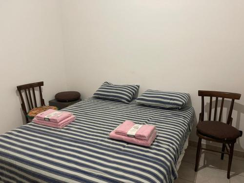 twee roze zakken op een bed met twee stoelen bij Affitti brevi "Max FORTUNA" in Ragusa