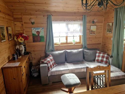 a living room with a couch in a log cabin at Unique Caravan with Outdoor Space Lodge in Ballantrae