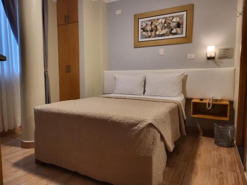 ワチョにあるHotel Punta Rocas - Huachoのベッドルーム(白い枕の大型ベッド1台付)
