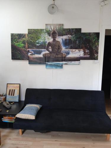 - un canapé noir dans le salon orné de 4 peintures dans l'établissement Grand T5 le canal, à Agen