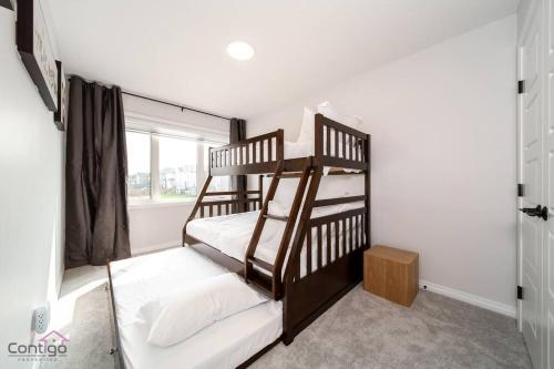 a bedroom with two bunk beds and a window at The Obsidian, AC, Sleeps 14, Near YEG Airport in Edmonton