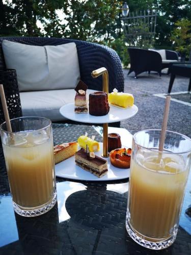 une table avec une assiette de nourriture et deux verres de jus d'orange dans l'établissement Agréable Maison très proche de Tours, à La Riche