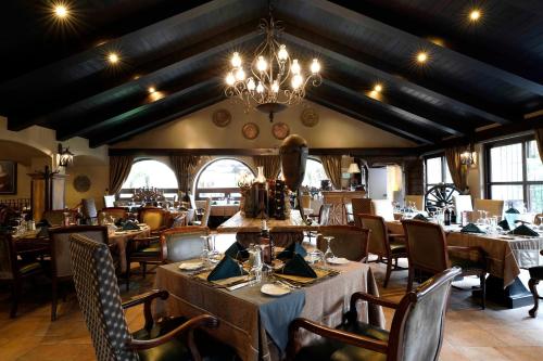 a dining room with tables and chairs and a chandelier at Camino Real Antigua in Antigua Guatemala