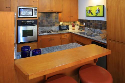 a kitchen with wooden cabinets and a wooden counter top at Peninsula Hideaway Apartment • Alamitos Bay in Long Beach