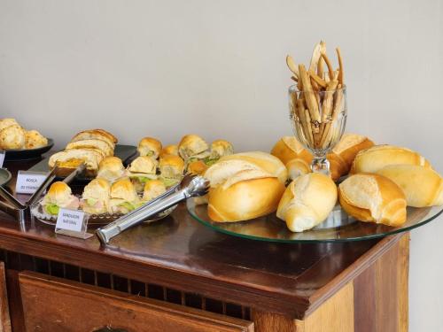 a table topped with a plate of buns and sandwiches at Serrano Exclusive in Tiradentes