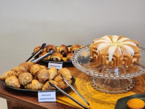 a table topped with trays of pastries and pies at Serrano Exclusive in Tiradentes