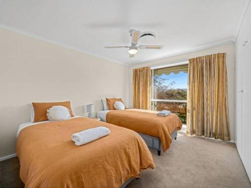 a bedroom with two beds and a window at Views on Quicks Hill in Lavington