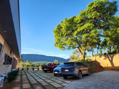 two cars parked in a parking lot next to a building at Serrano Exclusive in Tiradentes