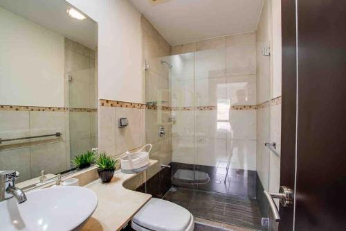 a bathroom with a toilet and a sink and a shower at CR MARIPOSA RENTALS Comfortable penthouse, AC, pool, gym, tennis in Santa Ana