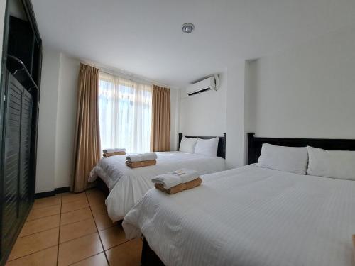 a hotel room with two beds and a television at Nacazcol - Playas del Coco in Coco