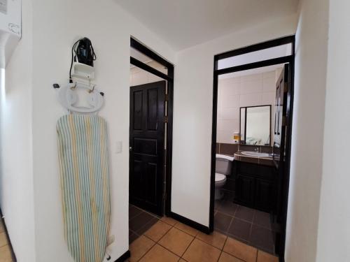 a bathroom with a toilet and a sink and a mirror at Nacazcol - Playas del Coco in Coco