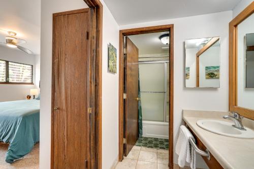 a bathroom with a sink and a bed and a mirror at Kaunakakai Home at Molokai Shores with Pool! in Kaunakakai