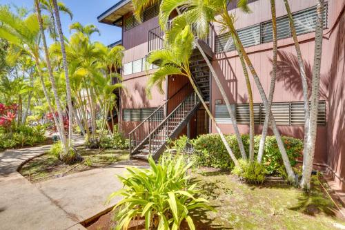 a building with palm trees in front of it at Kaunakakai Home at Molokai Shores with Pool! in Kaunakakai