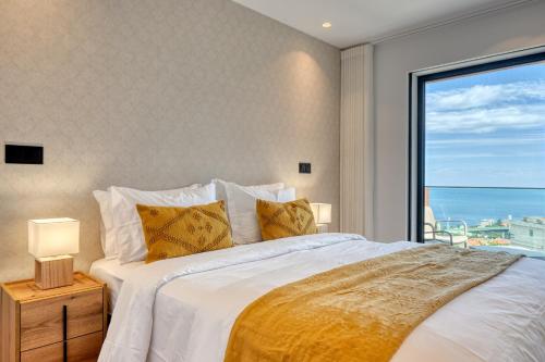 sypialnia z dużym łóżkiem i dużym oknem w obiekcie Becas Place, a Home in Madeira w Funchal