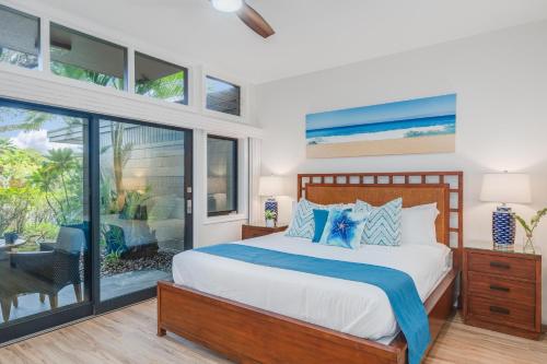 a bedroom with a bed and sliding glass doors at Kapalua Ridge Villas 2612 in Kahana