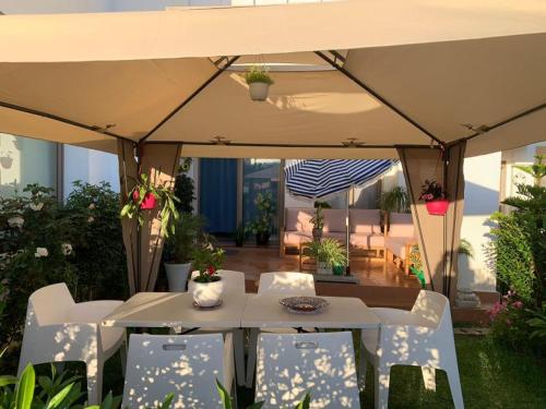 een patio met een tafel en stoelen onder een tent bij Appartement de vacances BERALMAR CHEZ HOUDA in Asilah