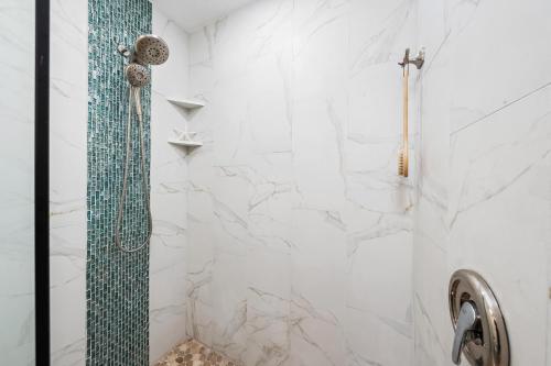 a bathroom with a shower with white marble walls at Kapalua Golf Villas 17T8 in Kahana
