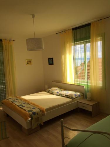 a small bedroom with a bed and a window at Apartments Stakic in Krvavica