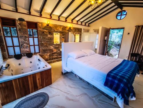 Schlafzimmer mit einem Bett und einer Badewanne in der Unterkunft Casa Piedra in Santa Sofía