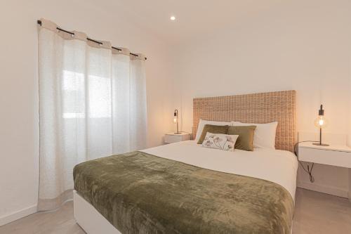 biała sypialnia z dużym łóżkiem i oknem w obiekcie Casa Pinhão w mieście Sesimbra