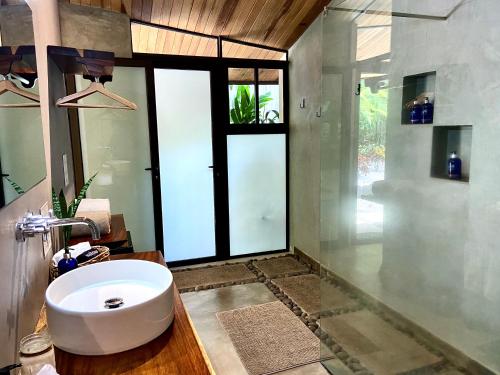 a bathroom with a sink and a large window at Villas Kalei in Playa Grande