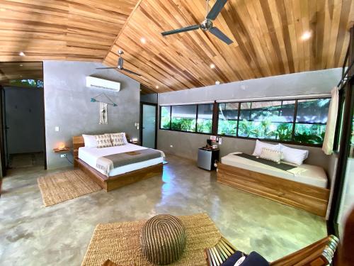 a bedroom with two beds and a large window at Villas Kalei in Playa Grande