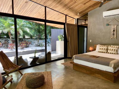 a bedroom with a bed and a large window at Villas Kalei in Playa Grande
