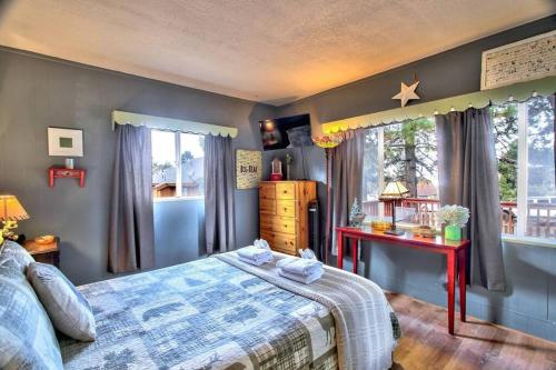 a bedroom with a bed and a table and a window at Los Osos w/ Privarte Spa and BBQ in Big Bear Lake