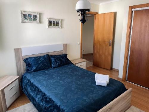 a bedroom with a blue bed and a wooden door at Casa da Levada in Tomar