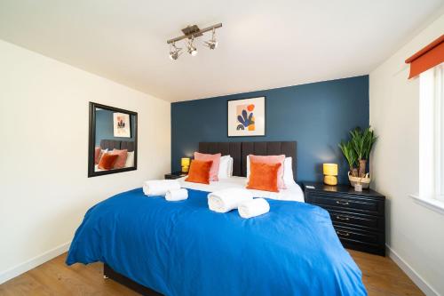 a bedroom with a blue bed with orange pillows at Westland Shores in Crail