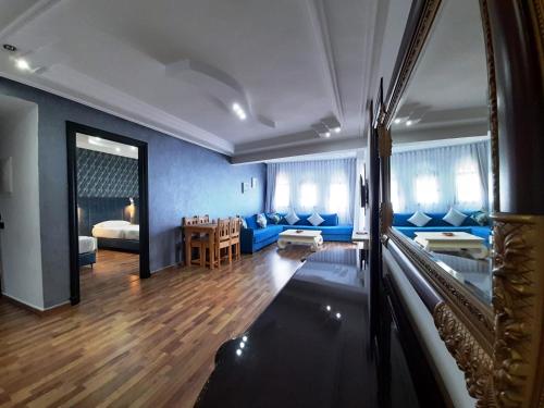 uma sala de estar com um sofá azul e uma mesa em Balcon Bleu em Chefchaouen