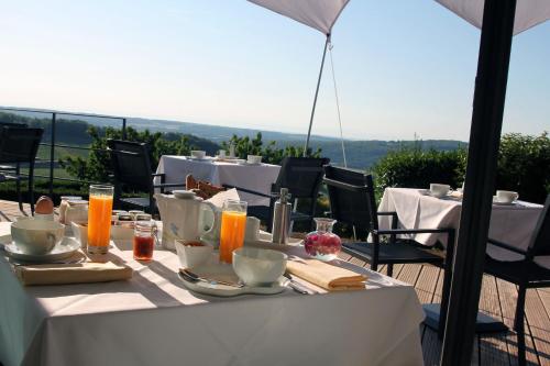 een tafel met eten en drinken bovenop een balkon bij Hôtel Restaurant La Montagne De Brancion in Martailly-lès-Brancion