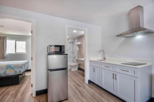 a white kitchen with a sink and a refrigerator at Studio 6 Eureka CA Old Town in Eureka