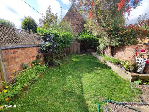 un jardín con una pared de ladrillo y un patio en St Lucia lodge Leicester long stays available en Leicester