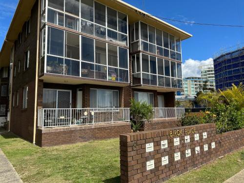a building with a brick wall in front of it at Meridian Tower Kirra Beach in Gold Coast