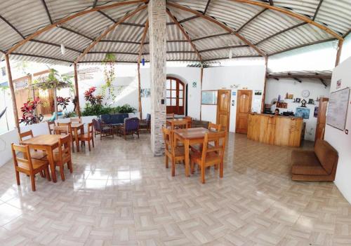 uma sala de jantar com mesas e cadeiras num edifício em Hostal White House Galapagos em Puerto Ayora