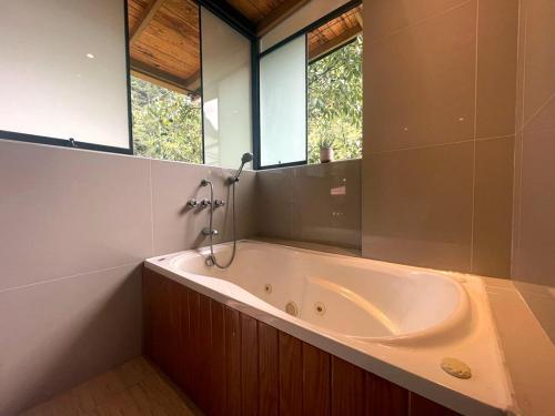 La salle de bains est pourvue d'une baignoire et d'un miroir. dans l'établissement Supertramp Hostel Machupicchu, à Machu Picchu