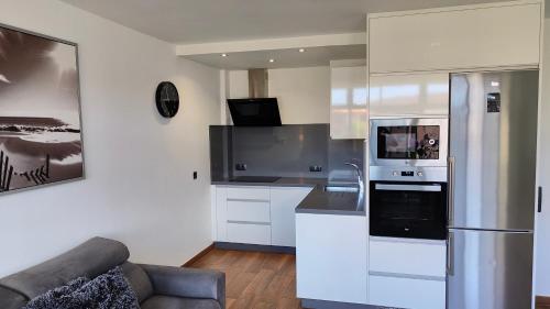 una cocina con electrodomésticos blancos y un sofá en una habitación en ALAMO LUXURY APARTMENT en Playa del Ingles