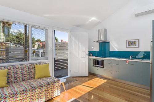 a living room with a couch and a kitchen at Hobart studio - Courtyard on Argyle in New Town