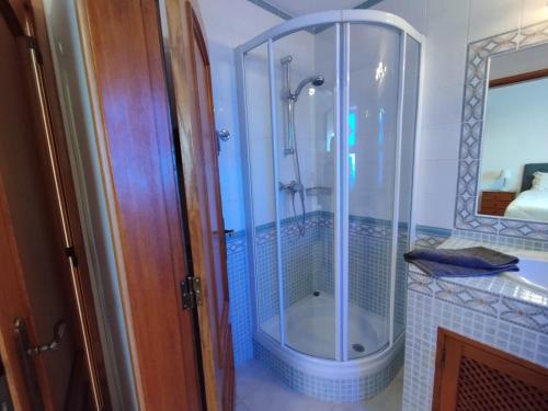 a bathroom with a shower with a glass enclosure at Villa Serena in Olhão