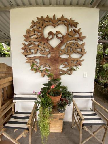a wooden heart wall art with two benches at Cabañas Los Tulipanes in La Mesa