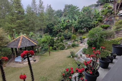 a garden with flowers and a gazebo at PineHill on a 1740m land in Lembang