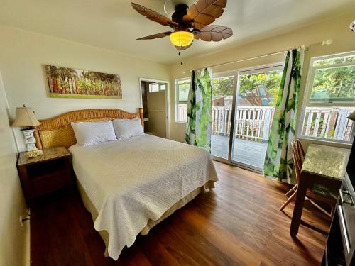 a bedroom with a bed and a ceiling fan at Mokulē'ia Beach Houses at Owen's Retreat in Waialua