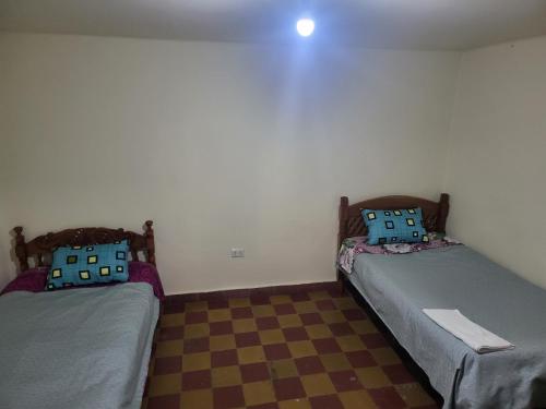 dos camas sentadas una al lado de la otra en una habitación en Edén en Tarija